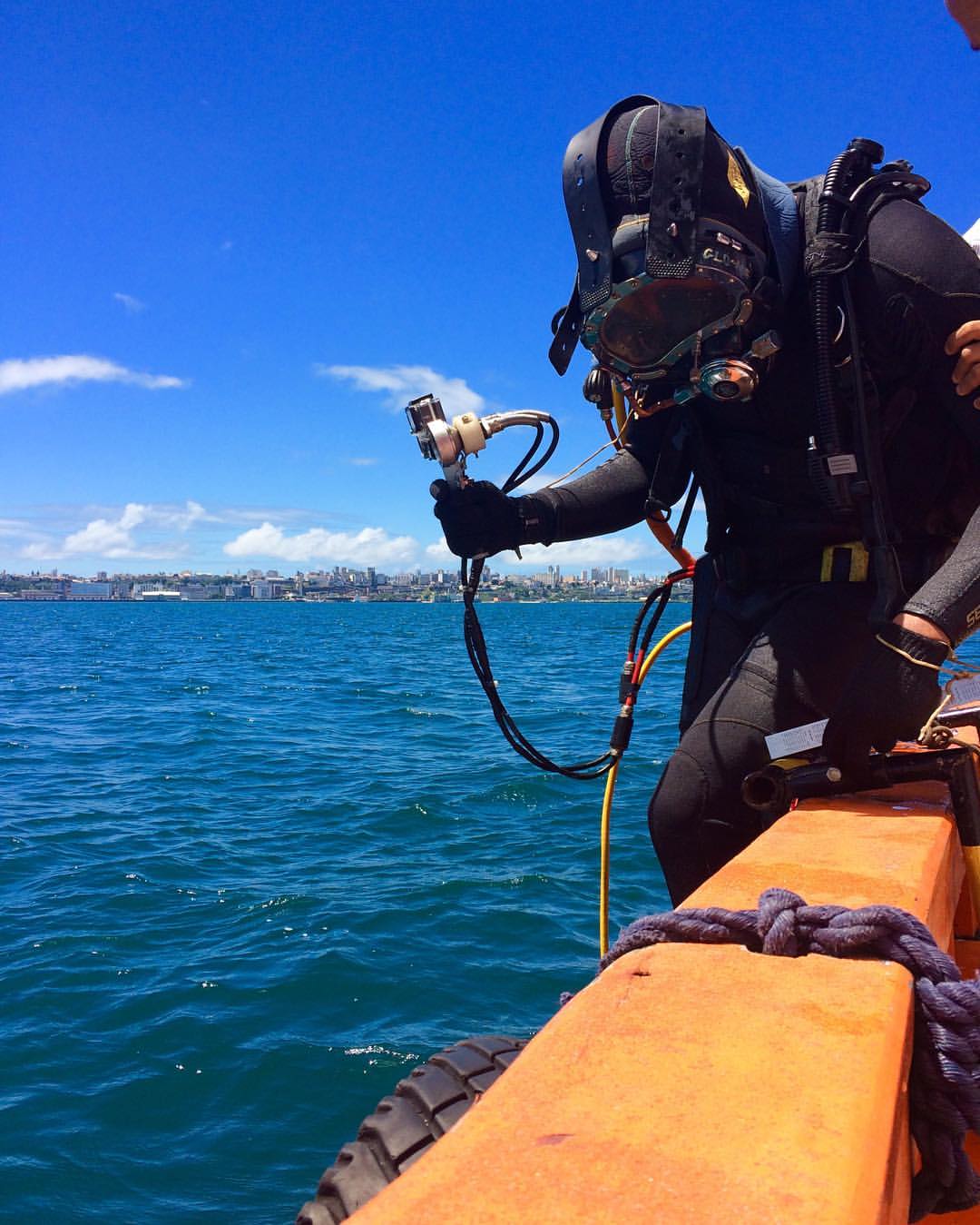Mergulhador com capacete KMB realizando inspeção de casco de navio